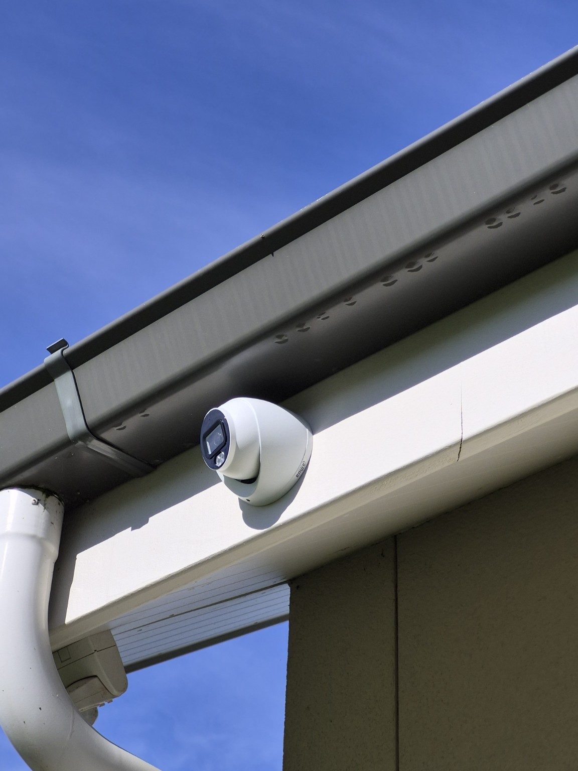 Security camera installed under the eaves near a gutter