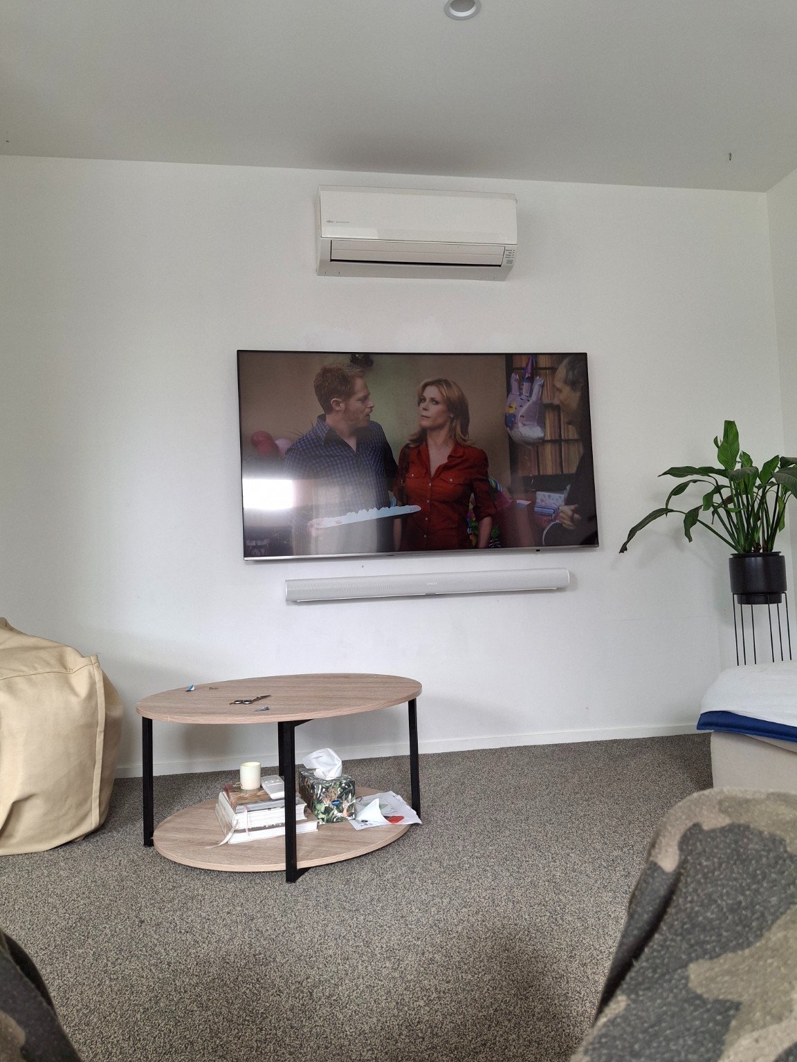 Wall-mounted TV with soundbar in a lounge room